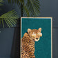 Cool Cheetah Art Print by Sarah Manovski in a room with a plant and navy blue panelled wall